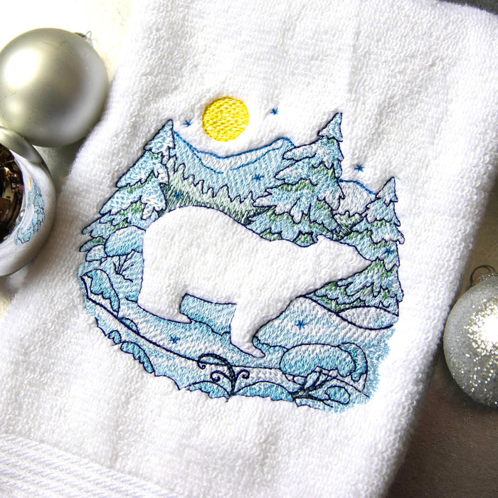Machine embroidered embossed polar bear on towel surrounded by ornaments.